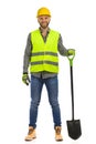 Handsome smiling construction worker is standing with spade. Front view. Studio shot