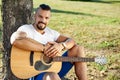 Handsome smiling man with acoustic guitar ina summer park Royalty Free Stock Photo