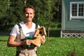 The handsome man in uniform making a birdhouse and smiling.