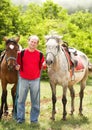 Handsome smiling man with horses Royalty Free Stock Photo