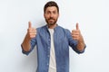 Handsome smiling man standing on white background and showing ok sign with fingers Royalty Free Stock Photo