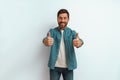 Handsome smiling man standing on white background and showing ok sign with fingers Royalty Free Stock Photo