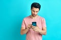 Handsome smiling man using smart phone on blue studio background Royalty Free Stock Photo