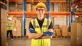 Handsome Smiling Worker Wearing Hard Hat, Standing with Crossed Arms in the Retail Warehouse full Royalty Free Stock Photo