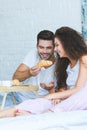 handsome smiling young man feeding beautiful girlfriend