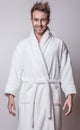 Handsome smiling young man in luxurious bathrobe. Royalty Free Stock Photo