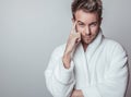 Handsome smiling young man in luxurious bathrobe. Royalty Free Stock Photo