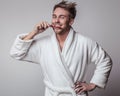 Handsome smiling young man in luxurious bathrobe. Royalty Free Stock Photo