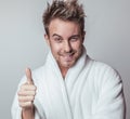 Handsome smiling young man in luxurious bathrobe. Royalty Free Stock Photo