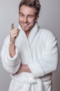 Handsome smiling young man in luxurious bathrobe. Royalty Free Stock Photo