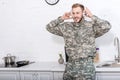 handsome soldier in military uniform wearing headphones and listening music