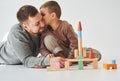 Handsome son kissing his father. Paternity. Dad and his son playing with colored wooden blocks on white background. Royalty Free Stock Photo