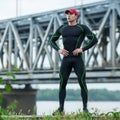 Handsome sport man in sportswear outdoor. Active male outside on the background of the bridge
