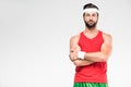 handsome sportsman posing in retro sportswear and sunglasses with crossed arms,