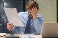 Handsome stressed businessman sitting at desk in his office Royalty Free Stock Photo