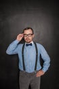 Handsome strict teacher in eyeglasses looking at you on blackboard Royalty Free Stock Photo