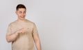 Handsome strong young man pointing finger to the right with a surprised expression on his face Royalty Free Stock Photo