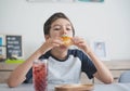 A handsome student schoolboy 8-9 years old wearing black glasses having snack Royalty Free Stock Photo