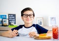 A handsome student schoolboy 8-9 years old wearing black glasses having snack Royalty Free Stock Photo