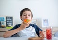 A handsome student schoolboy 8-9 years old wearing black glasses having snack Royalty Free Stock Photo