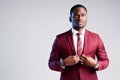 Handsome stylish african american businessman straightens his suit buttoning his jacket