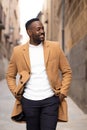 Handsome and stylish african american walking and looking aside while he is smiling on a street Royalty Free Stock Photo