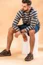 Handsome stylish bearded man in striped sweatshirt sitting Royalty Free Stock Photo