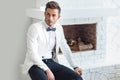 Handsome stylish man in elegant suit sitting near fireplace Royalty Free Stock Photo