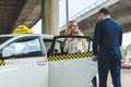 handsome stylish man opening car door to smiling blonde woman sitting Royalty Free Stock Photo