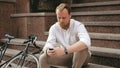 Handsome stylish man sitting on stone stairs with mobile phone Royalty Free Stock Photo