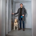 Handsome stylish man standing with labrador dog in elevator Royalty Free Stock Photo