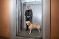 Handsome stylish man standing with labrador dog in elevator Royalty Free Stock Photo