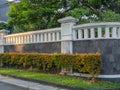 A Handsome and Stylish Solid Fence Wall design with Foliage Decoration