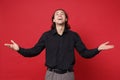 Handsome stylish young curly long haired man in black shirt posing isolated on red wall background studio portrait Royalty Free Stock Photo