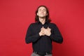 Handsome stylish young curly long haired man in black shirt posing isolated on red wall background studio portrait Royalty Free Stock Photo