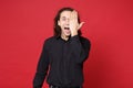 Handsome stylish young curly long haired man in black shirt posing isolated on red wall background studio portrait Royalty Free Stock Photo