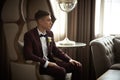 Handsome stylish young man awaiting his bride sitting in a vintage armchair