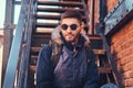 A handsome stylish young man sitting on stairs outside. Royalty Free Stock Photo