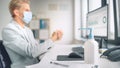 Handsome Stylish Young Man Wearing Protective Face Mask Uses Hand Sanitizer while Working at His D Royalty Free Stock Photo