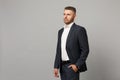 Handsome successful confident young business man in classic black suit shirt posing isolated on grey wall background Royalty Free Stock Photo