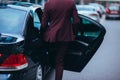 Handsome suited businessman entering the back of his black limo Royalty Free Stock Photo