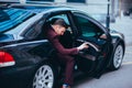 Handsome suited businessman entering the back of his black limo Royalty Free Stock Photo