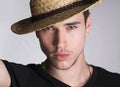 Handsome sultry young man with straw hat