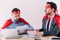 handsome super businessmen in masks and capes working with documents