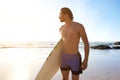 Handsome surfer carrying surfboard at the beach Royalty Free Stock Photo