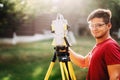 handsome surveyor working with total station with coordinates, cartography industry details Royalty Free Stock Photo
