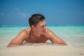 Handsome tanned sexy man on the shore of the ocean at the tropical island luxury resort