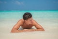 Handsome tanned sexy young man in the ocean in swimming wear at tropical beach at island luxury resort Royalty Free Stock Photo