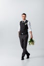 Handsome tattooed elegant bridegroom walking with