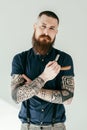 handsome tattooed man holding razor and looking